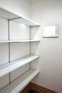 白を基調とした清潔感のあるシューズクローク。高さを自由に変えられる可動棚と、換気用の小窓を設置。