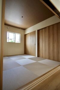 半畳畳と木目調の建具、木の色に合わせた茶色のアクセント天井が調和するモダンな和室の内観